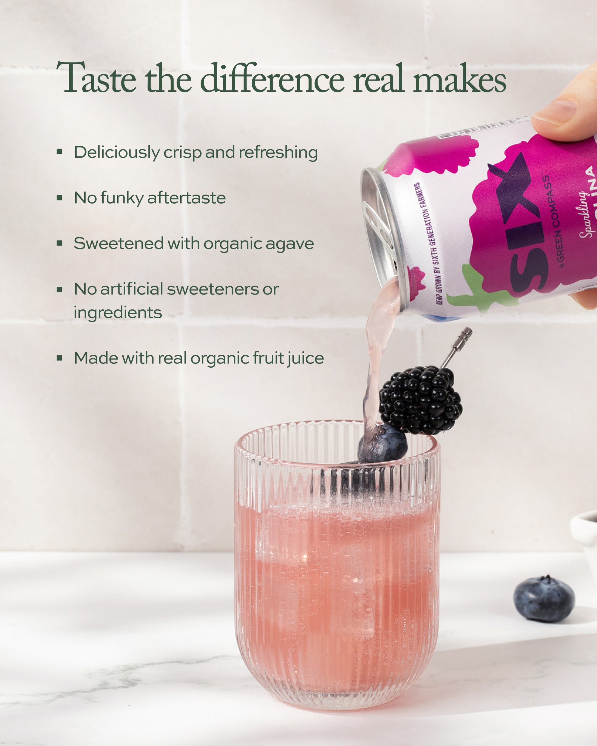 Person pouring a drink from a can into a glass with blackberries and blueberries on a marble surface six sparking carolina berry