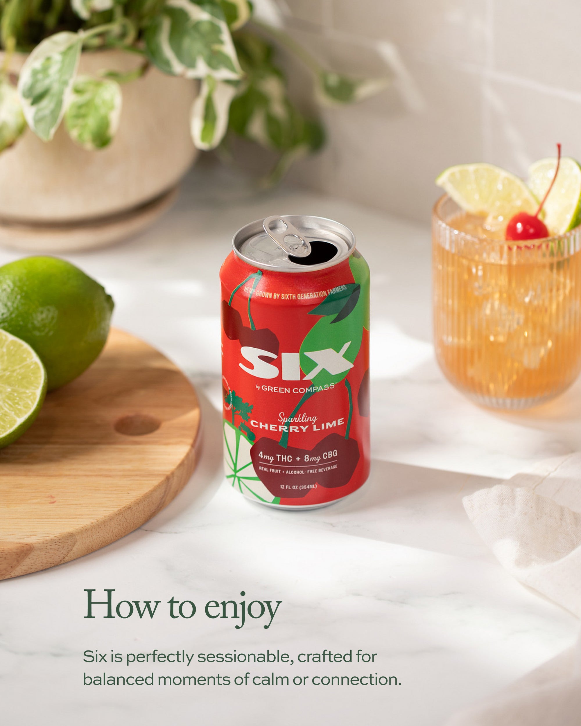 Six cherry lime can on a table with a drink of cherries and limes