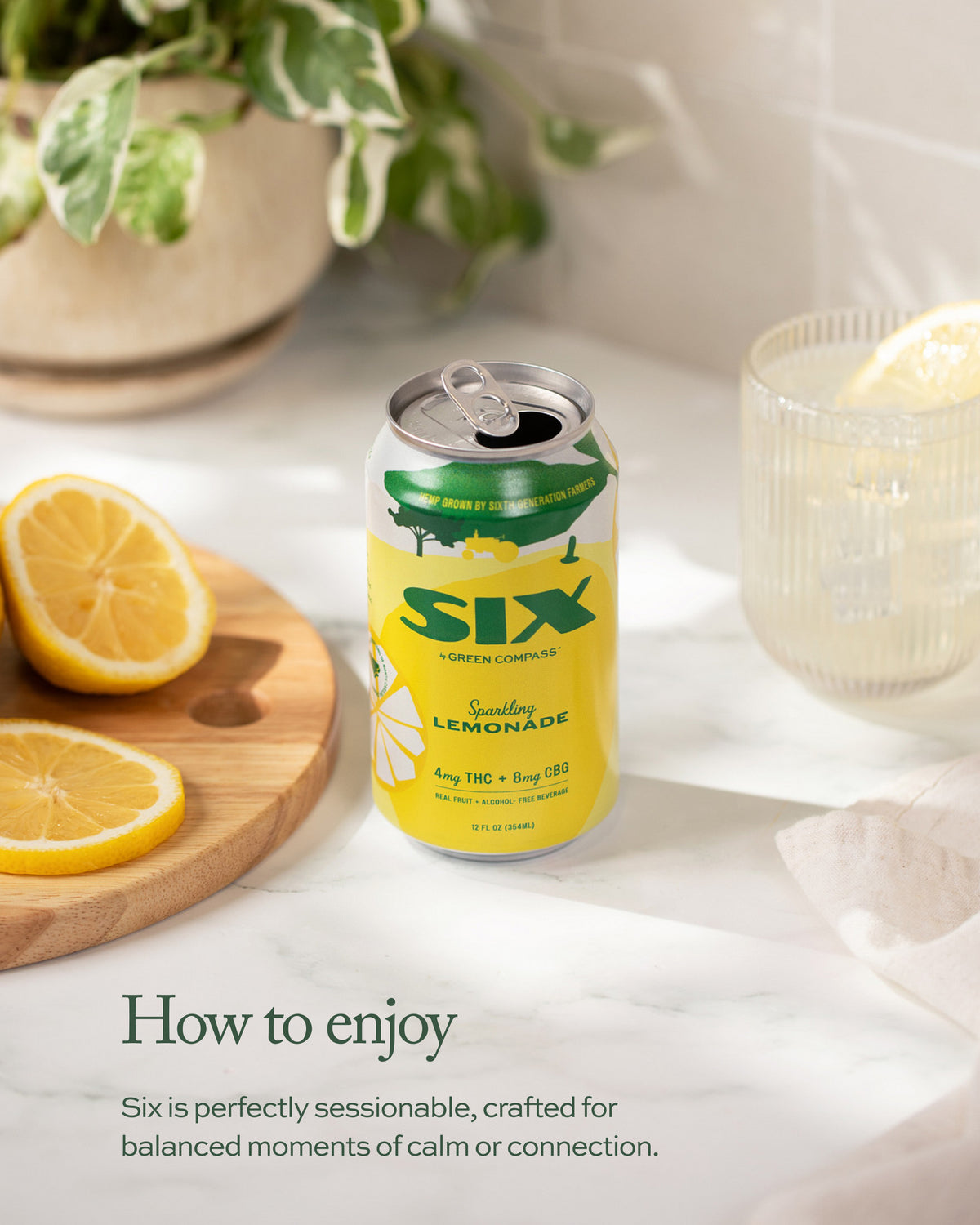 Can of Six Lemonade with lemons and a glass on a light surface